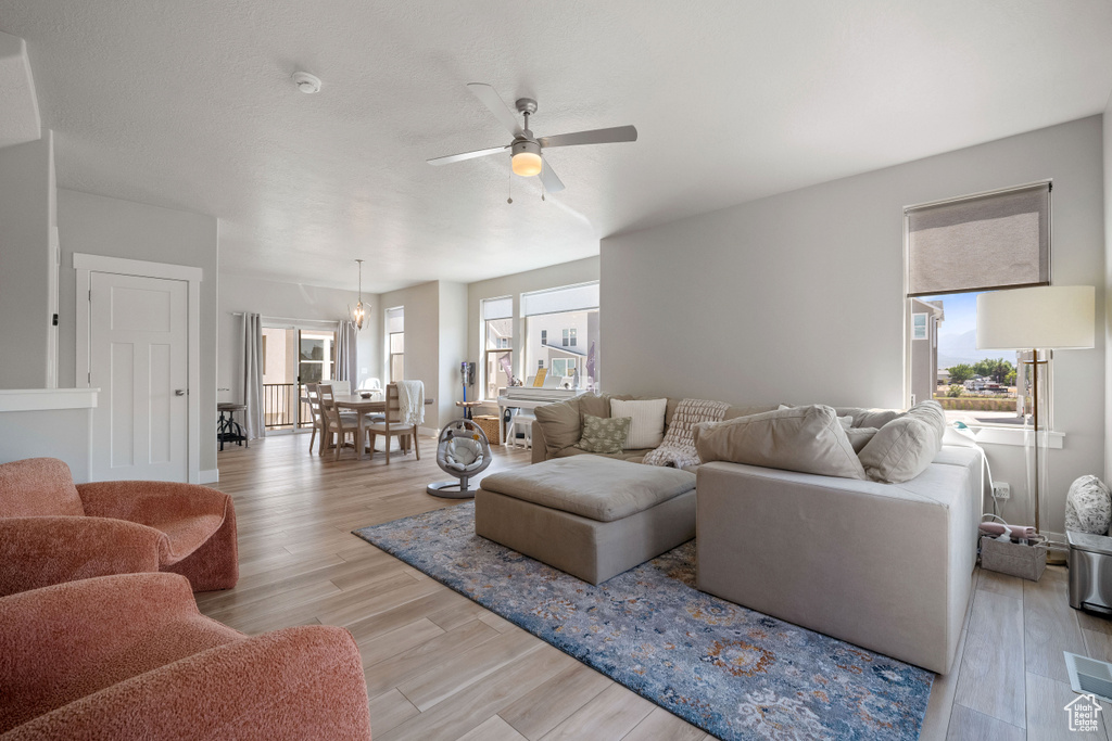 Living area featuring a ceiling fan and light wood-type flooring