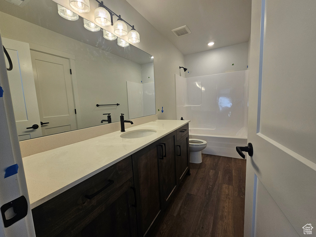 Bathroom featuring wood finished floors, vanity, and bathtub / shower combination