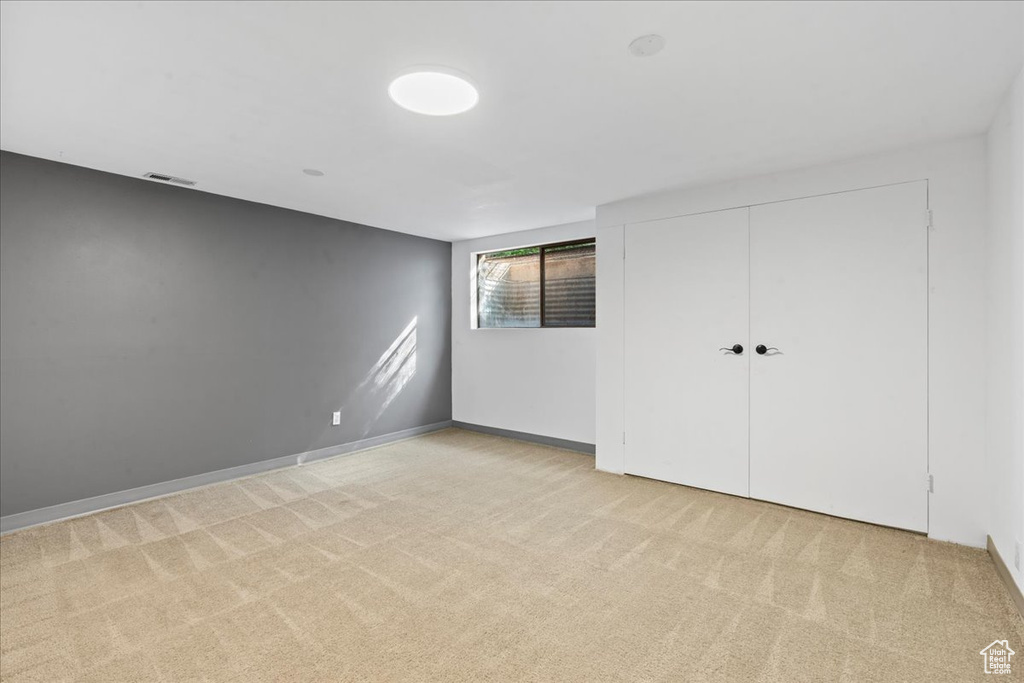 Unfurnished bedroom with light colored carpet and a closet