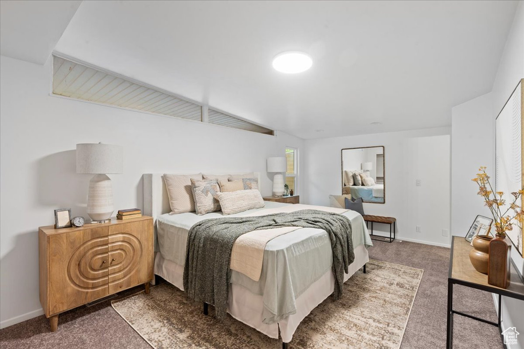 Bedroom featuring carpet floors and baseboards