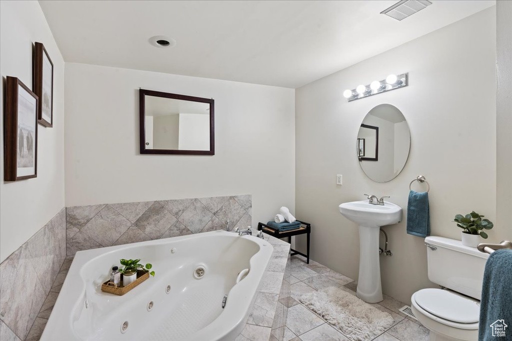Full bath with toilet and a whirlpool tub