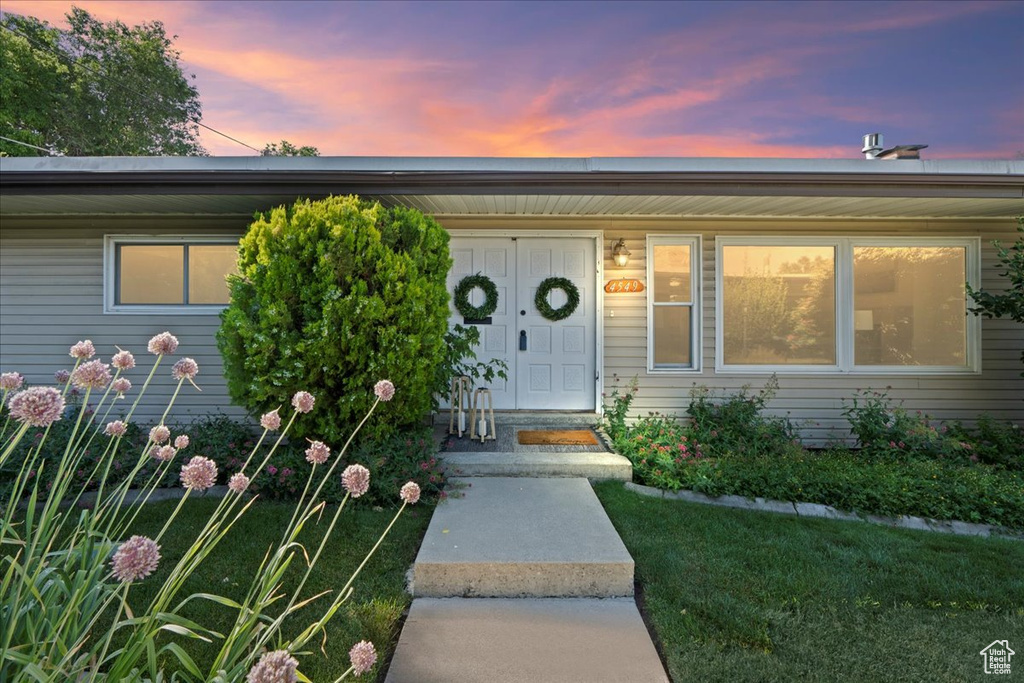 Exterior entry at dusk with a yard