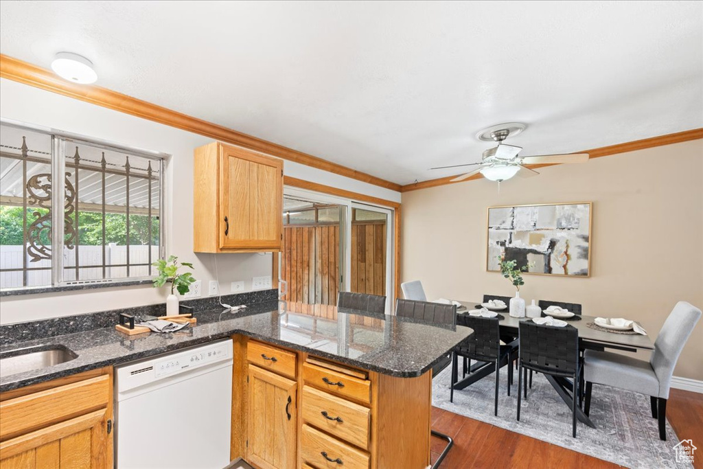 Kitchen with dishwasher, crown molding, a peninsula, ceiling fan, and dark wood finished floors