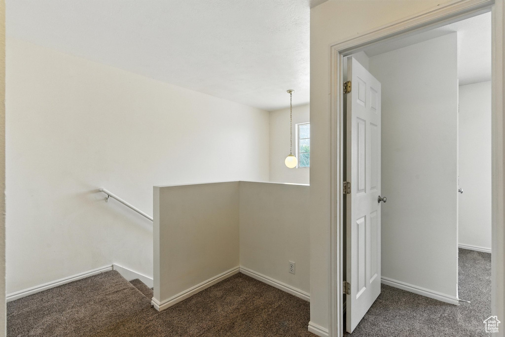 Hall featuring an upstairs landing and carpet flooring