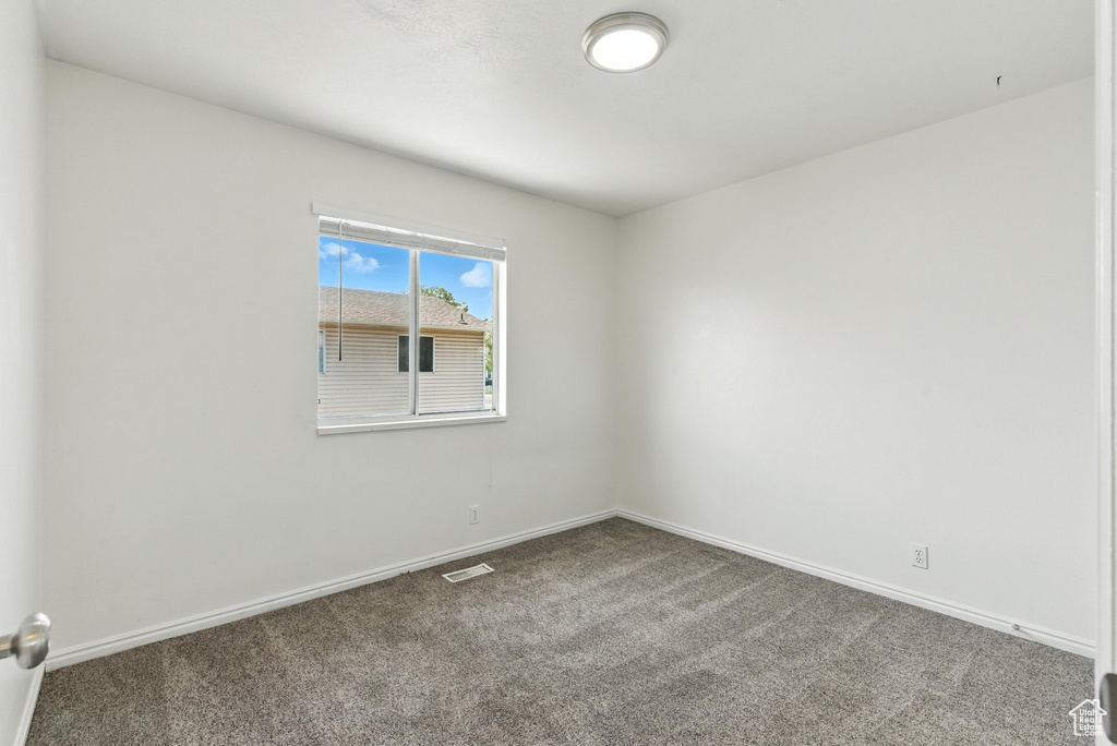 Empty room with carpet flooring and baseboards
