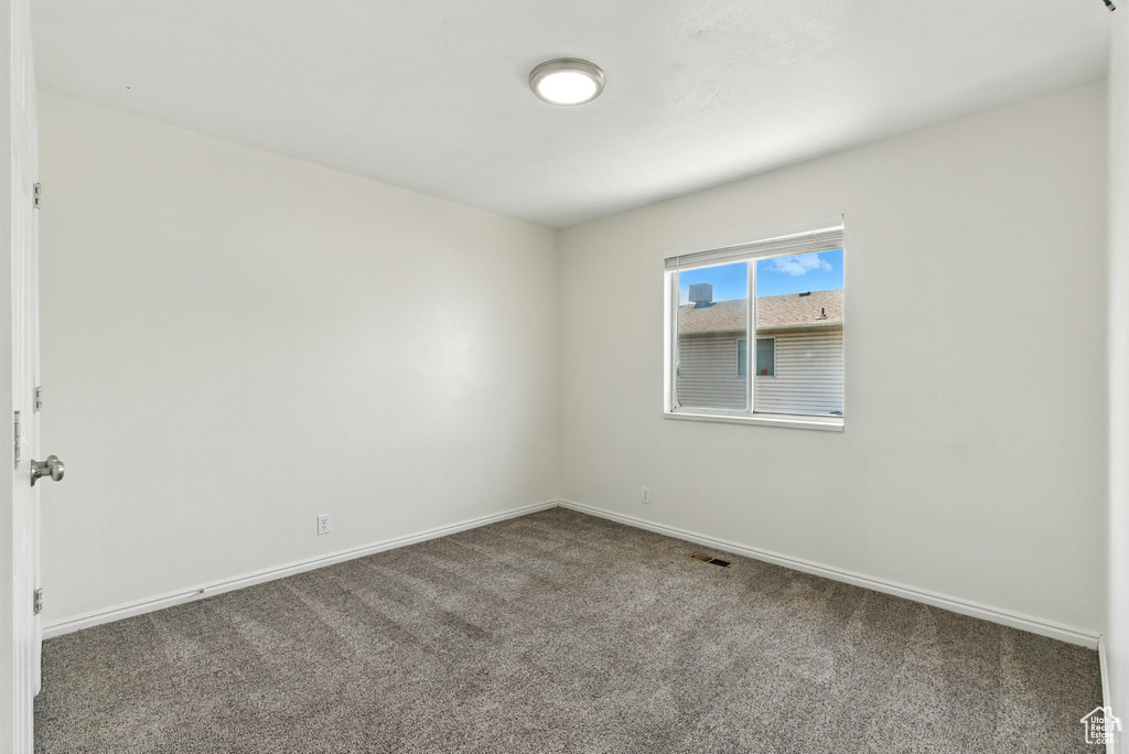 Carpeted empty room with baseboards