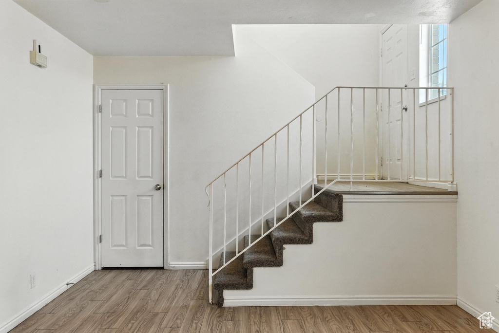 Stairway featuring wood finished floors