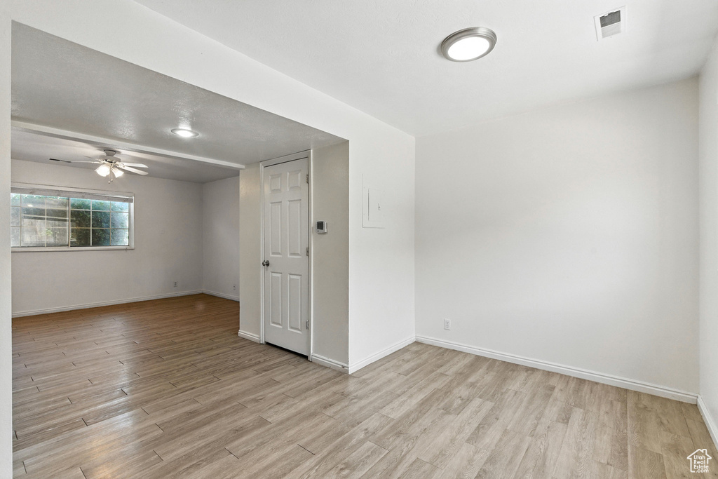 Unfurnished room featuring light wood-type flooring and ceiling fan