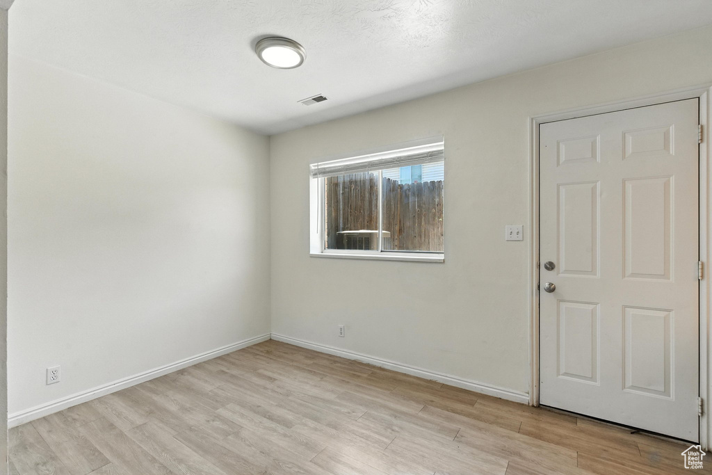 Unfurnished room with light wood finished floors and baseboards