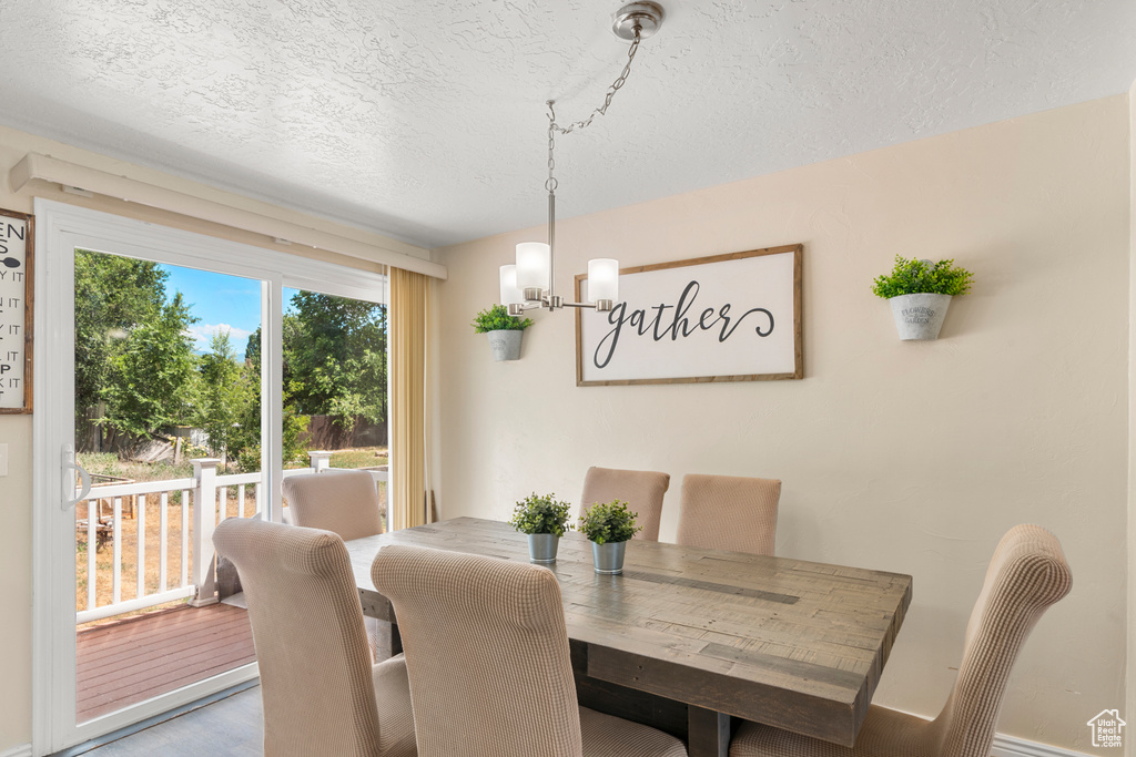 Dining space featuring a textured ceiling and a chandelier