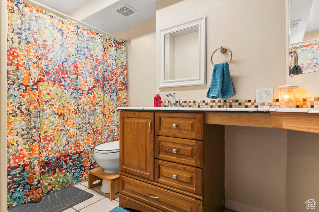 Bathroom featuring vanity, tile patterned floors, and a shower with shower curtain