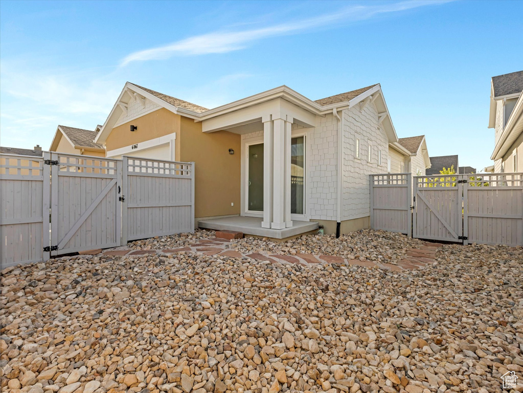 Back of property featuring a gate and a garage