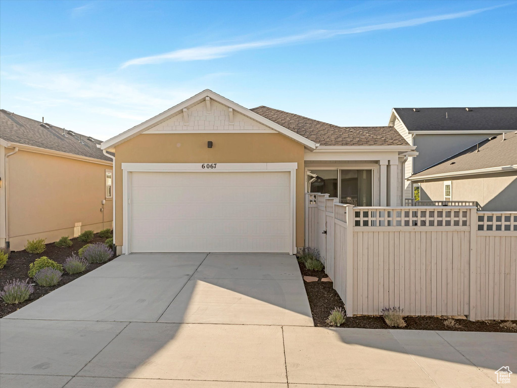 Ranch-style house featuring driveway, an attached garage, stucco siding, and a shingled roof