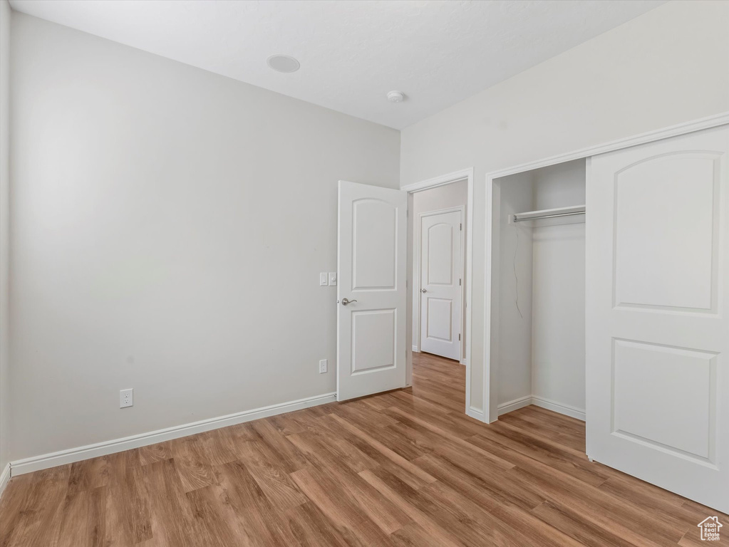 Unfurnished bedroom featuring light wood-type flooring and a closet