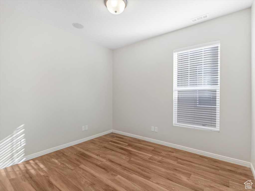 Unfurnished room featuring light wood finished floors and baseboards