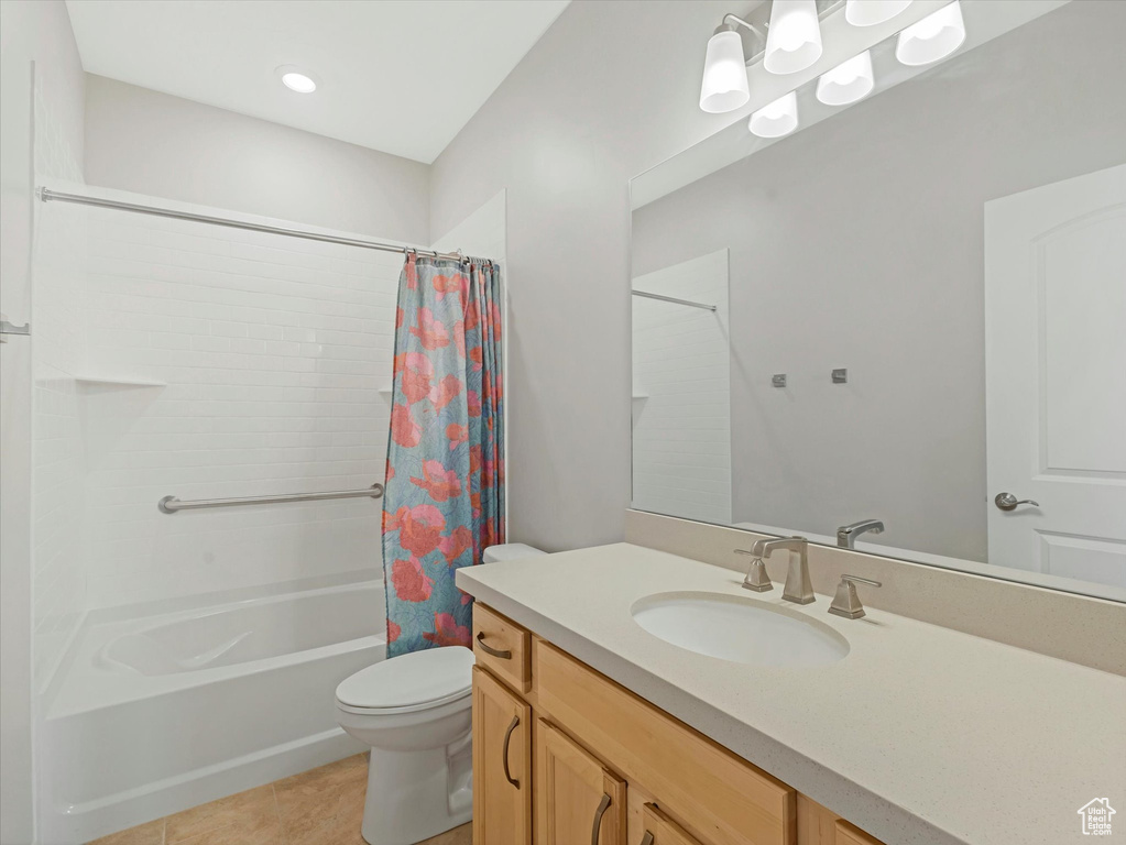 Bathroom featuring vanity, shower / tub combo, and tile patterned floors