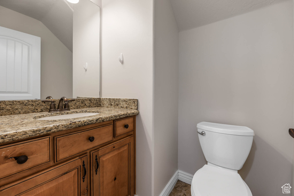 Half bath featuring vanity and lofted ceiling