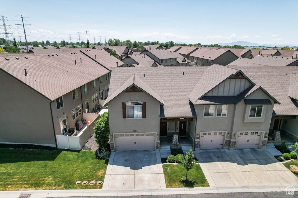 View of front of house featuring an attached garage, driveway, and stucco siding