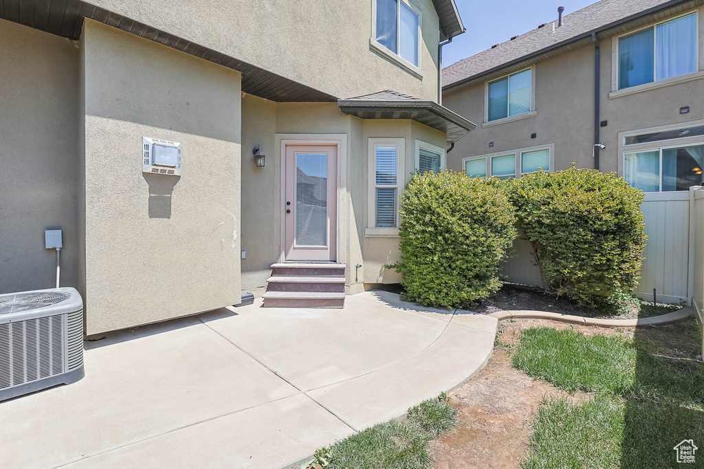 Property entrance with stucco siding and a patio