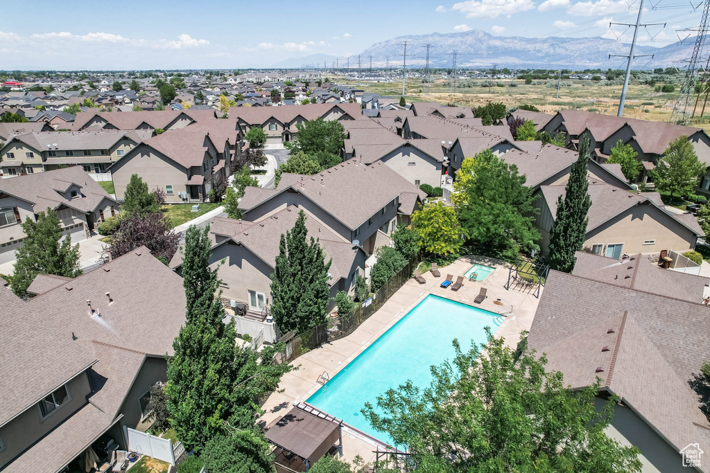 Aerial view of residential area featuring a mountainous background and a pool