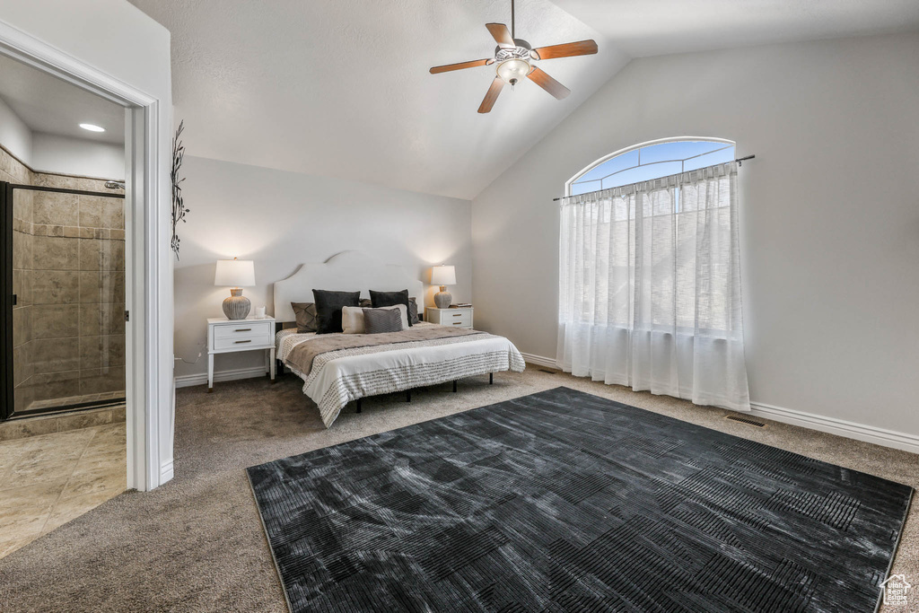 Carpeted bedroom with a ceiling fan and high vaulted ceiling