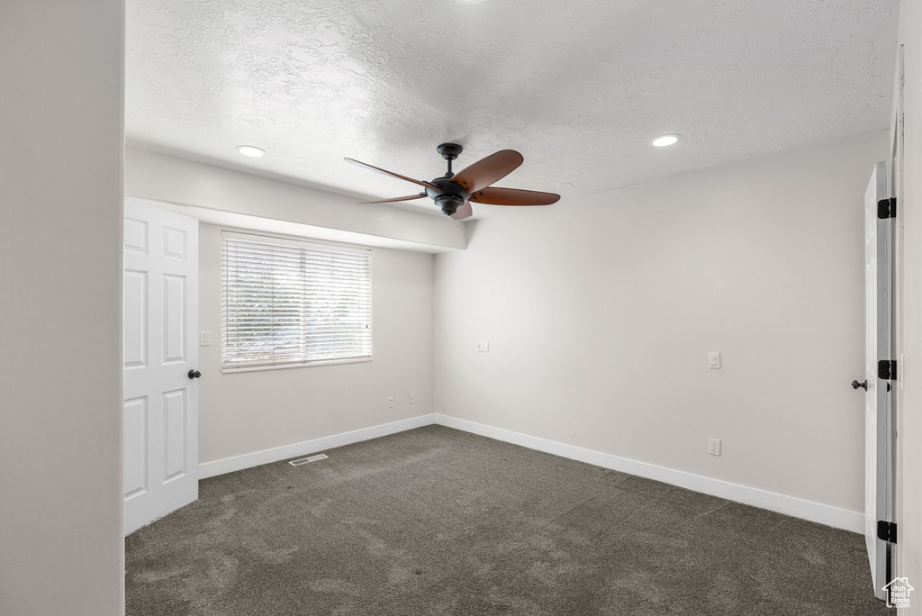 Unfurnished bedroom featuring dark carpet, a textured ceiling, recessed lighting, and a ceiling fan