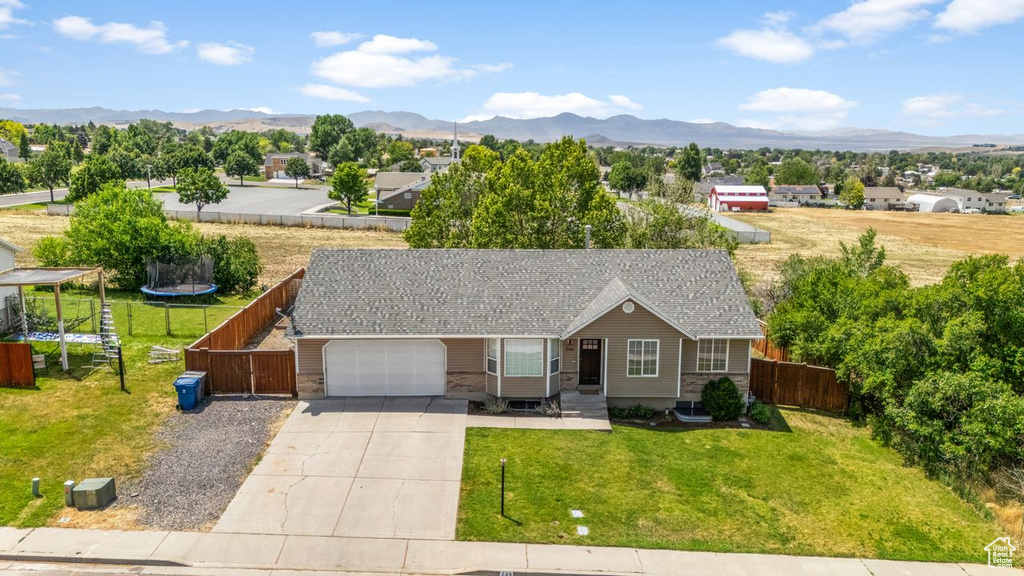 Ranch-style home featuring concrete driveway, an attached garage, and a mountain view