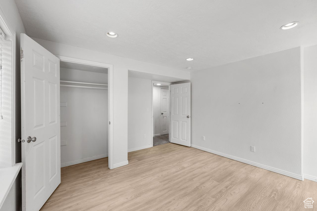 Unfurnished bedroom with light wood finished floors, recessed lighting, and a closet
