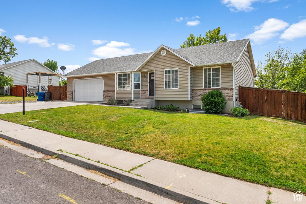 Ranch-style home featuring brick siding, concrete driveway, a garage, a gate, and roof with shingles