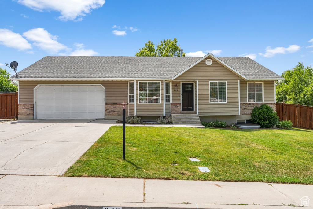 Ranch-style house with an attached garage, driveway, brick siding, entry steps, and roof with shingles