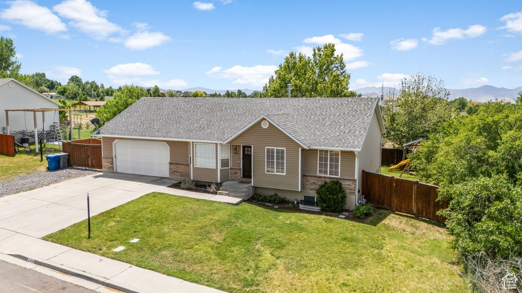 Single story home featuring brick siding, a mountain view, concrete driveway, a garage, and roof with shingles