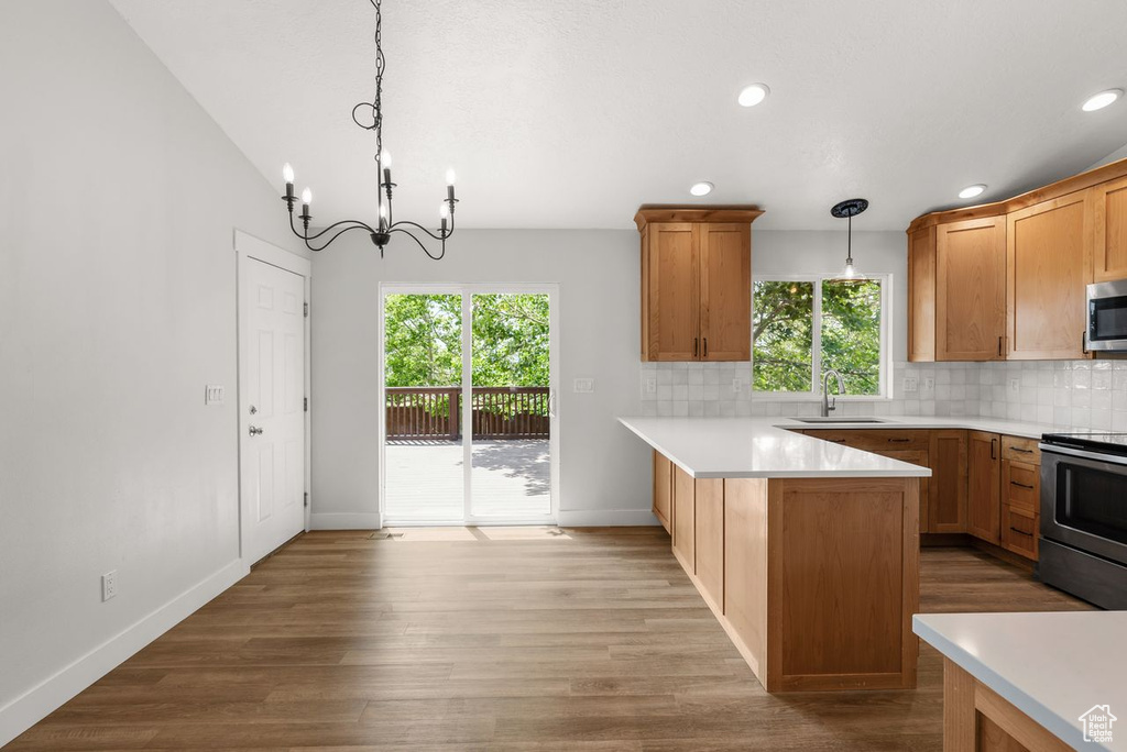 Kitchen with stainless steel appliances, a chandelier, plenty of natural light, light countertops, and recessed lighting