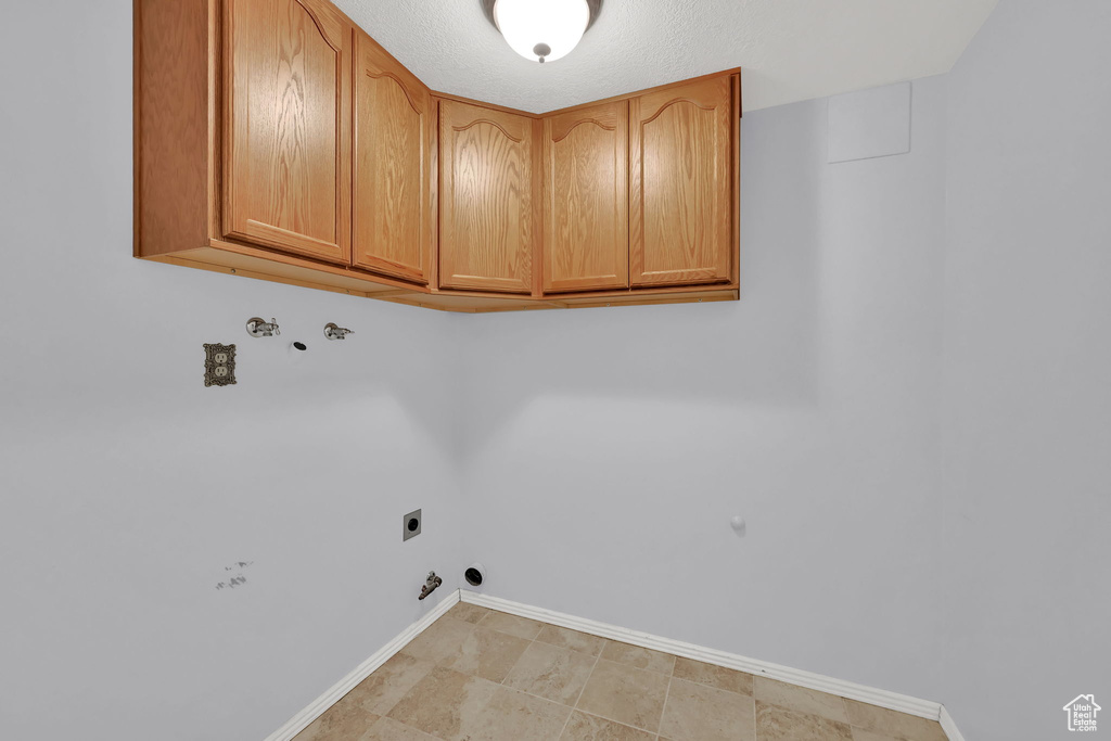 Laundry area with cabinet space, hookup for an electric dryer, and hookup for a washing machine