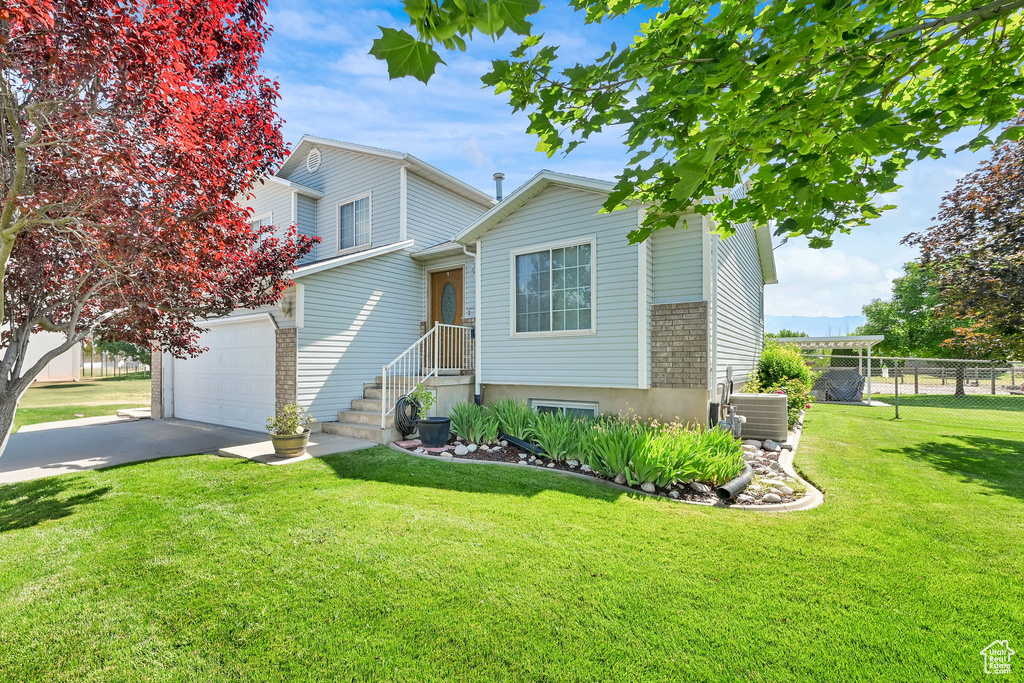 View of front of house featuring a garage, driveway, and brick siding