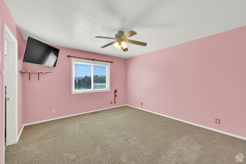 Spare room featuring a ceiling fan, carpet flooring, and a textured ceiling