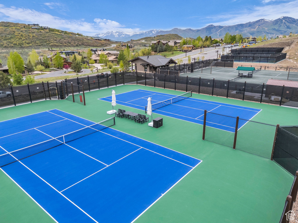 View of tennis court with a mountain view and community basketball court
