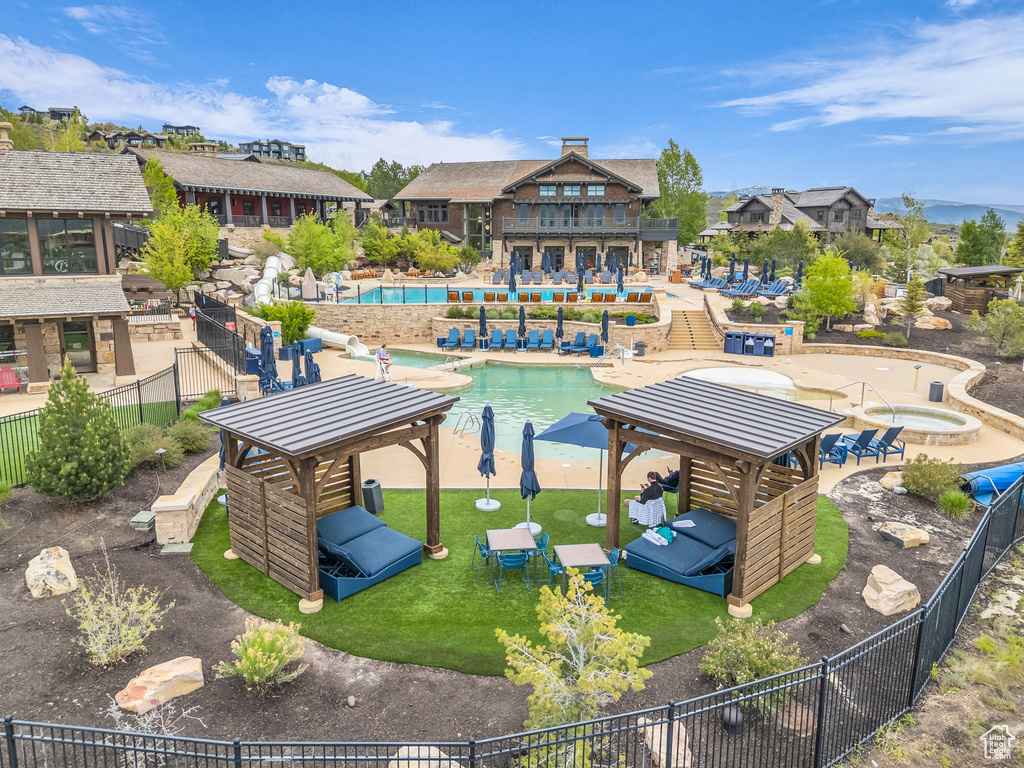 View of property\'s community with a hot tub, a swimming pool, a fenced backyard, a gazebo, and a patio