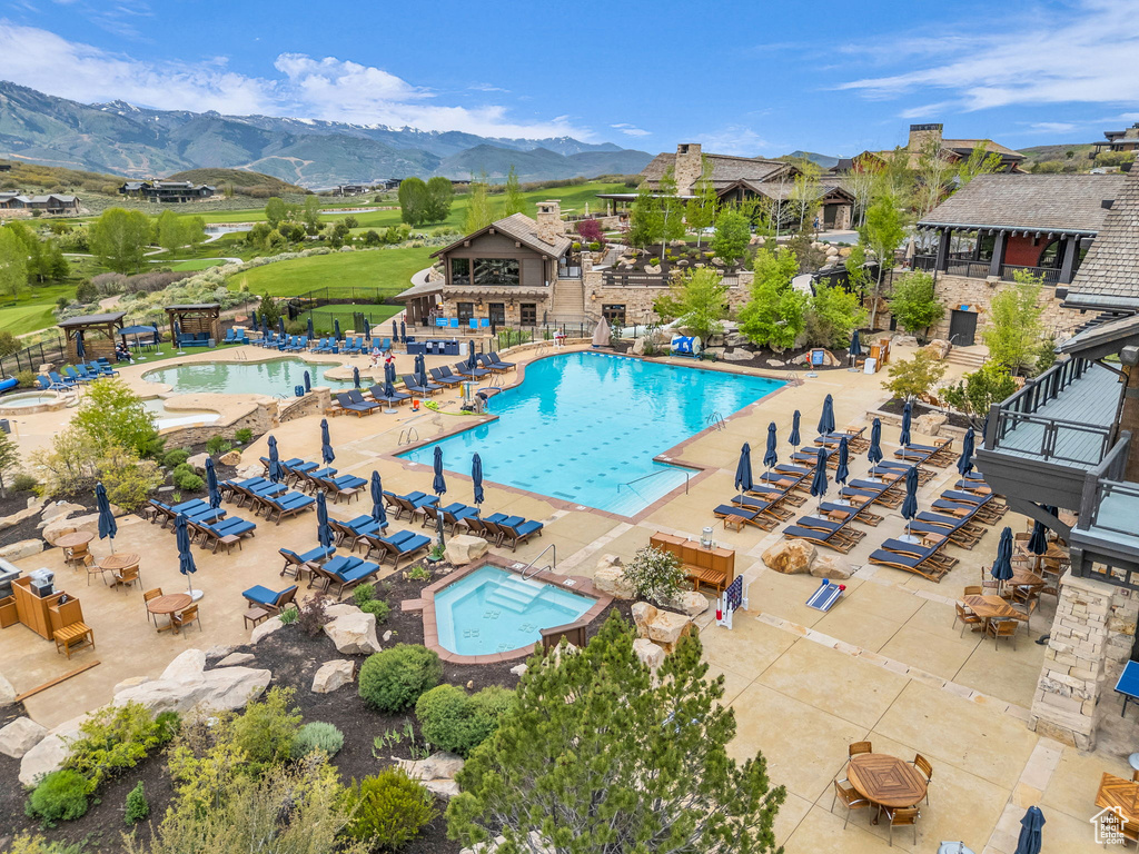 Community pool featuring a mountain view, a community hot tub, and a patio area
