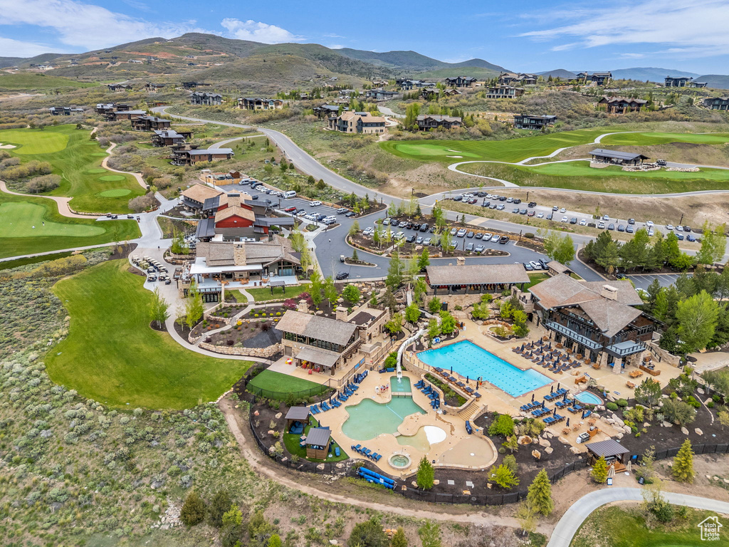 Aerial view of property\'s location with a mountainous background, a local golf course, and nearby suburban area