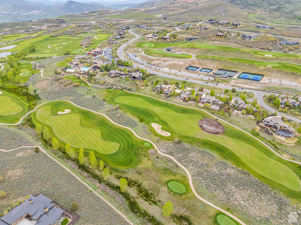 Aerial view of property and surrounding area featuring mountains, nearby suburban area, and a golf club