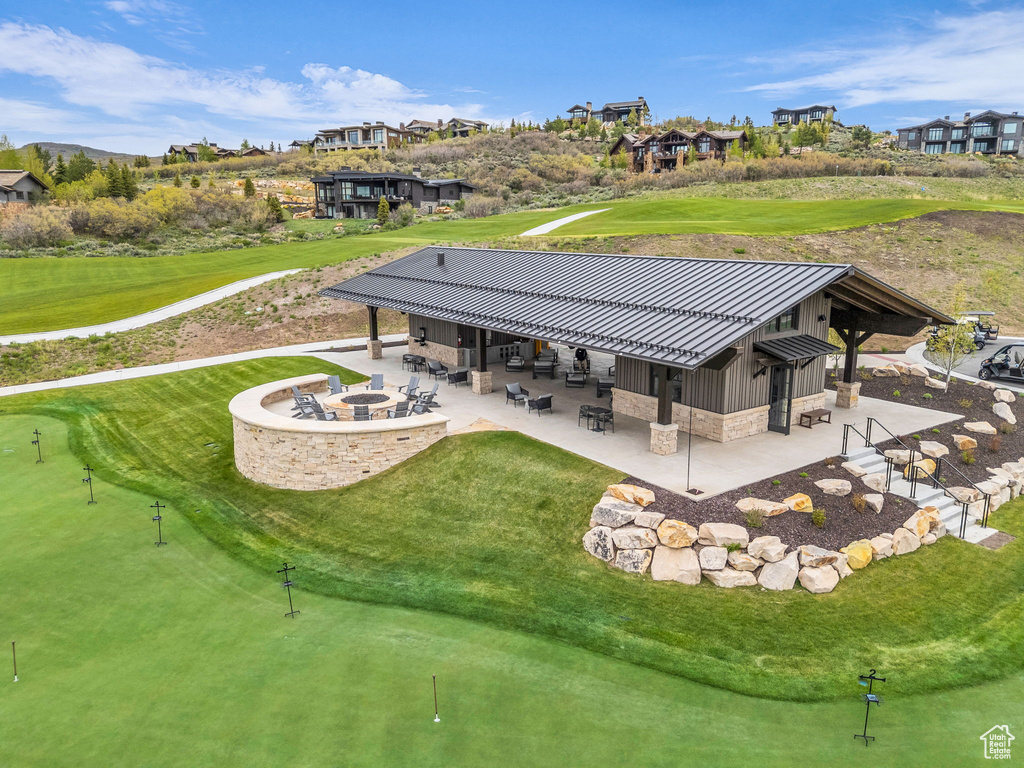 Back of property with board and batten siding, a patio area, a standing seam roof, a metal roof, and view of golf course