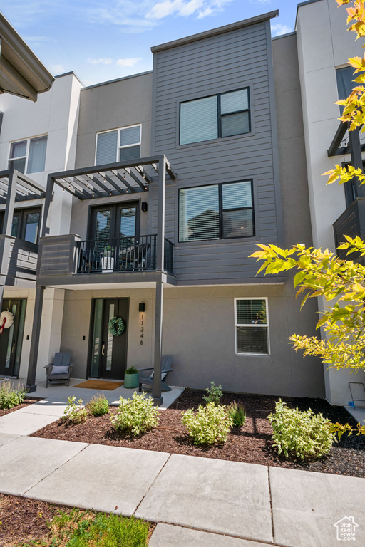 Multi unit property with a balcony, stucco siding, and french doors
