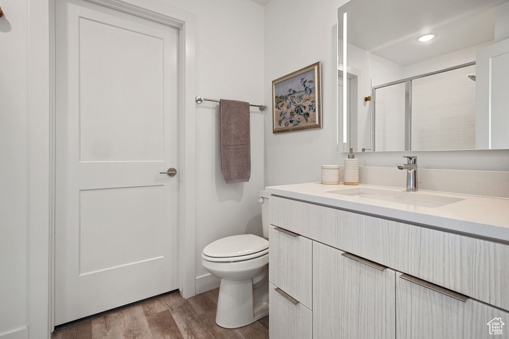 Full bath with wood finished floors, vanity, an enclosed shower, and recessed lighting
