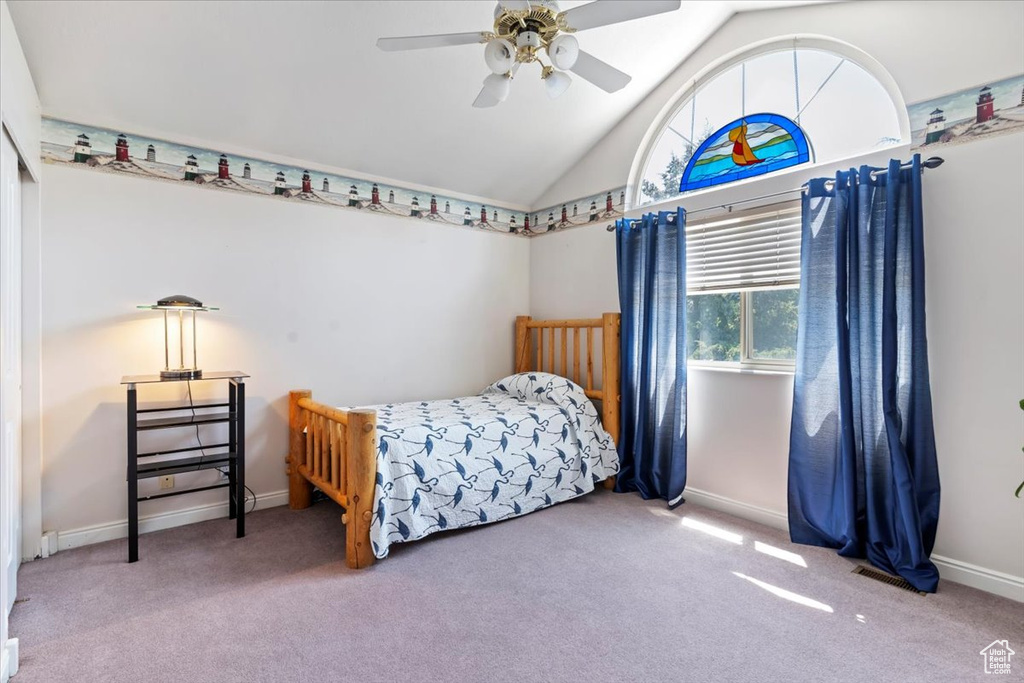 Carpeted bedroom featuring lofted ceiling and ceiling fan