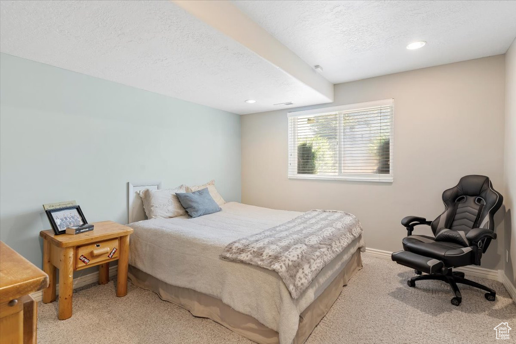 Bedroom featuring light colored carpet, a textured ceiling, and recessed lighting