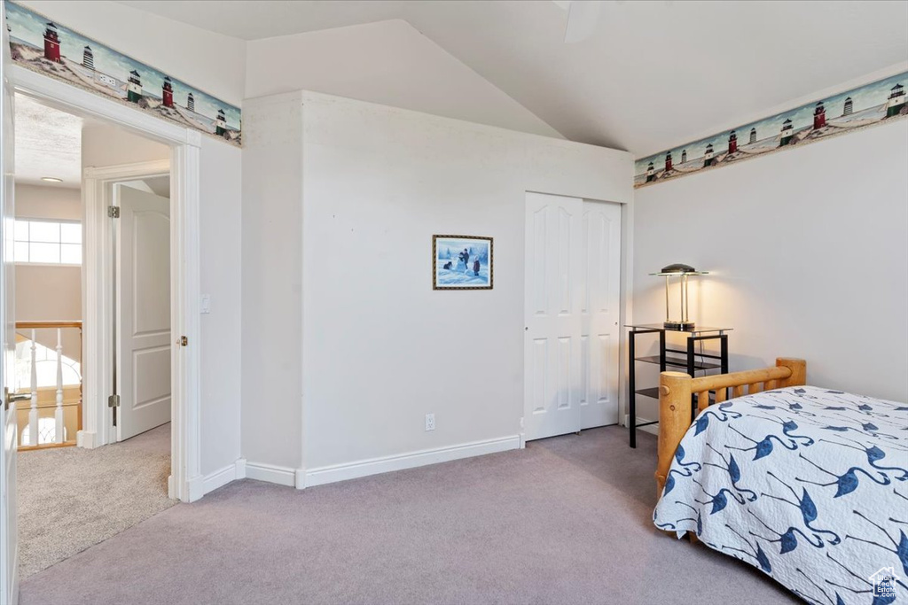 Carpeted bedroom with vaulted ceiling and a closet