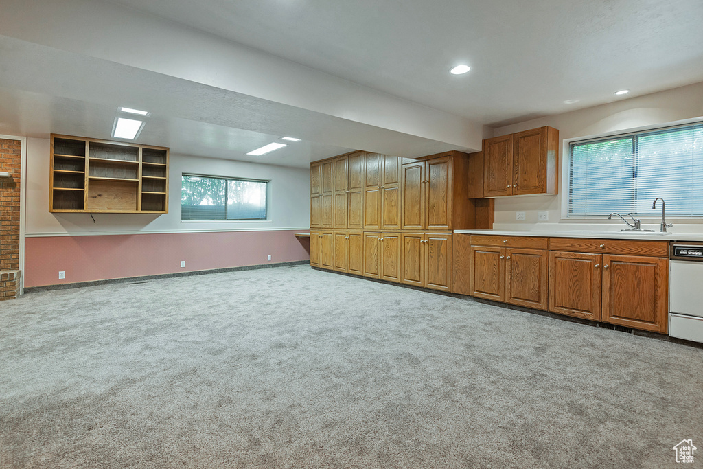 Kitchen featuring carpet flooring, brown cabinetry, dishwasher, recessed lighting, and light countertops