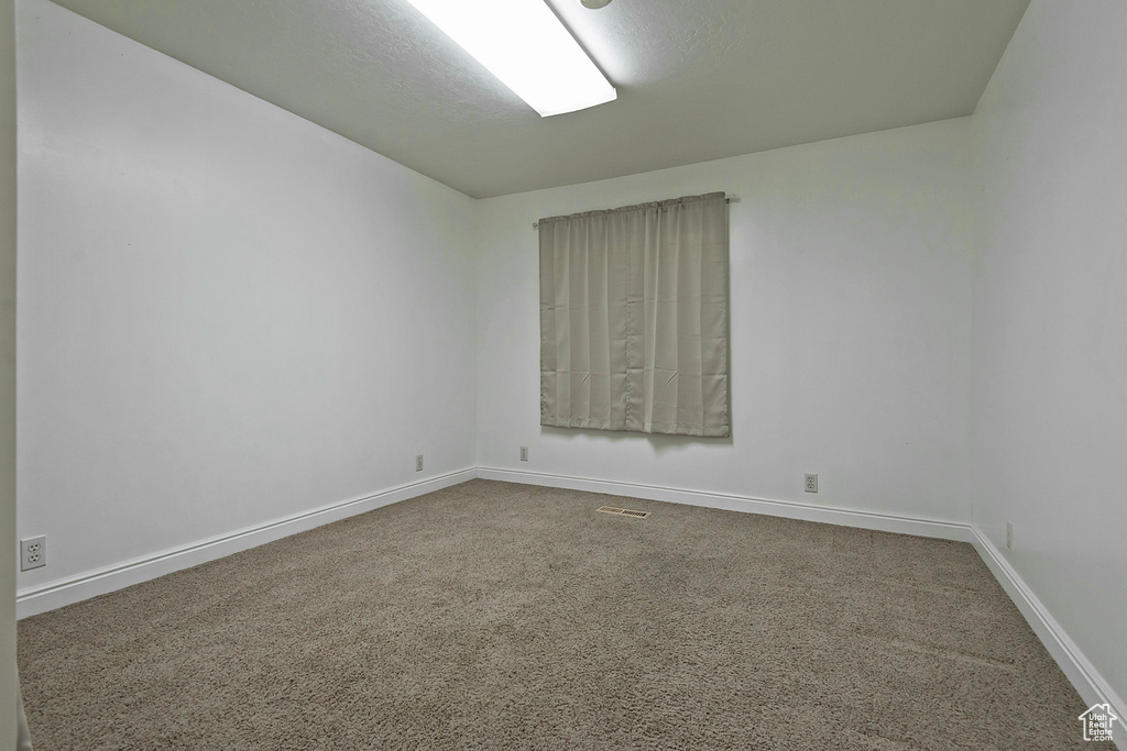 Carpeted empty room with baseboards