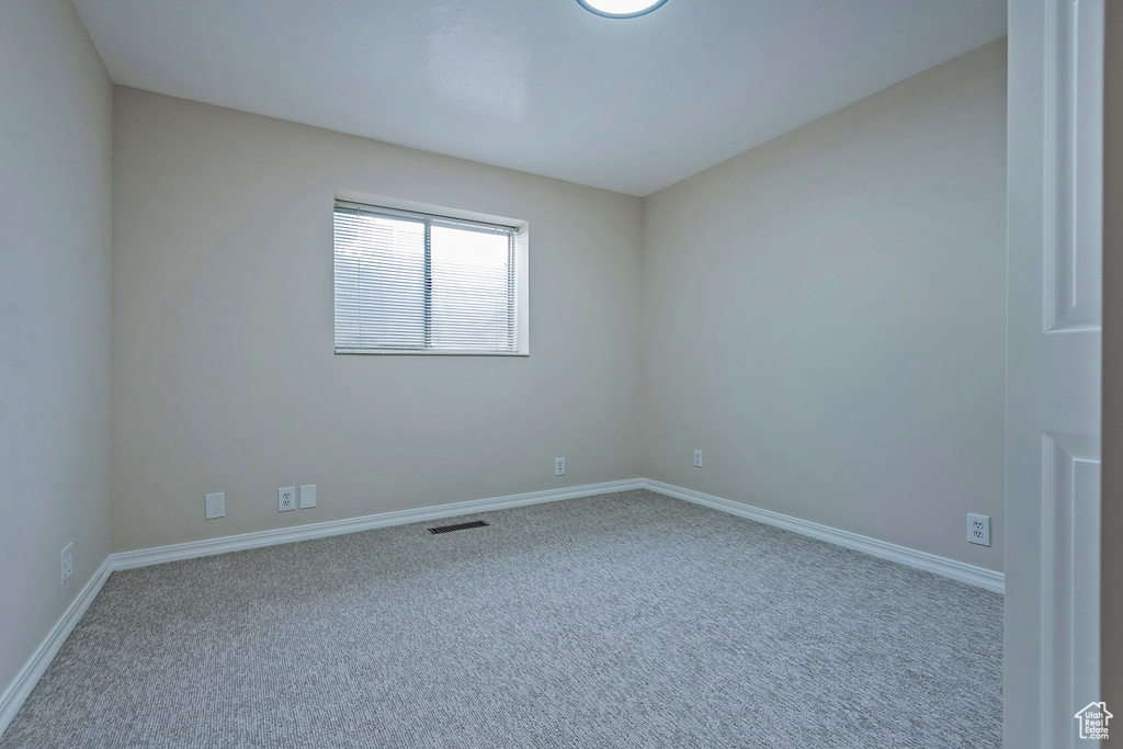 Carpeted empty room featuring baseboards