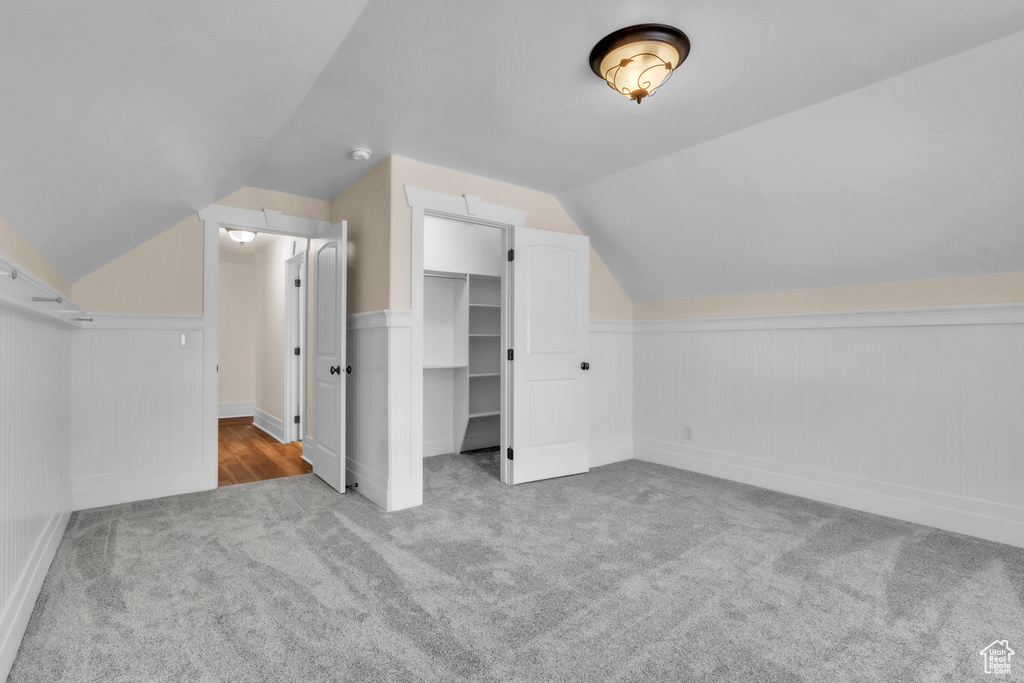 Additional living space with carpet floors and lofted ceiling
